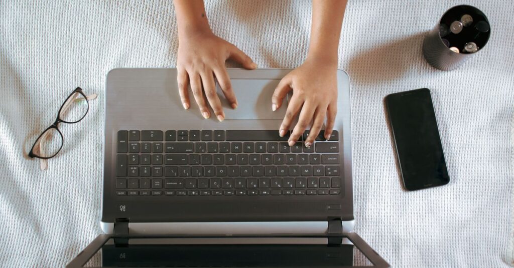 ノートPCでAIと一緒に楽しくブログを書いている様子を上から見た構図。